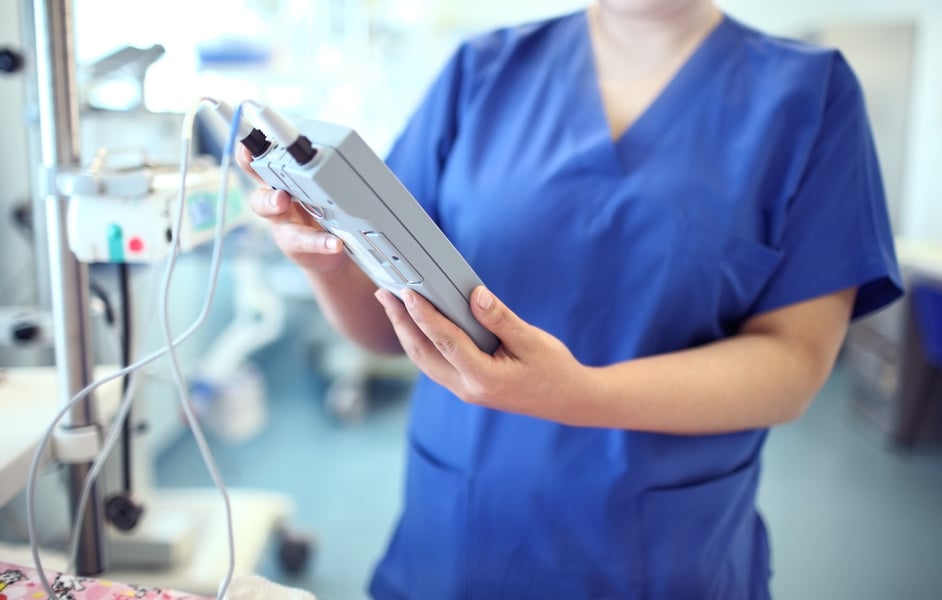 Female Doctor Adjust Electronic Medical Device